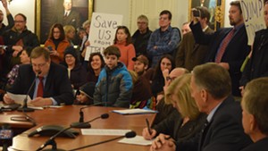 Vermont’s electors prepare to vote Monday while protesters look on.