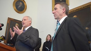 OneCare CEO Todd Moore addresses reporters Wednesday with Gov. Phil Scott to his right.