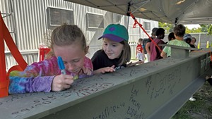 Kids signing the beam at the site of the new Burlington High School