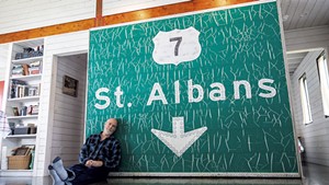 Paul Hance in front of a St. Albans exit sign on the first floor of his summer home