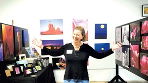 Trine Wilson, a member of the Milton Artists' Guild, standing in her gallery booth