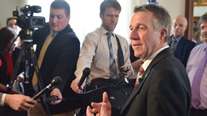 Gov. Phil Scott discusses health care negotiations with reporters Friday in his Statehouse office.