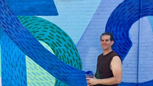 Alex Cook in front of his Cherry St. mural.