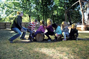 Kids play on a seesaw made from natural materials