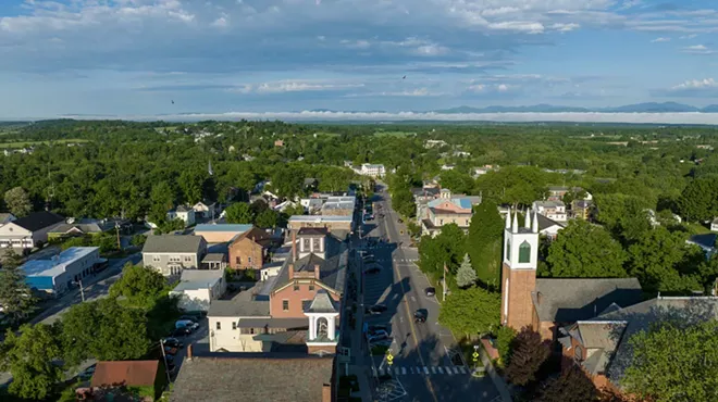 An aerial view of Vergennes showing historic buildings surrounded by trees alongside a street.