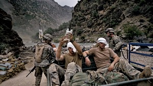 Wounded U.S. Army soldiers  await evacuation by helicopter from Kamdesh, Nuristan province.